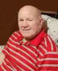 Man in red striped shirt sitting indoors.