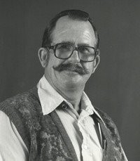 Man with mustache and glasses in vest