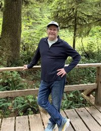 Man standing on forest bridge smiling