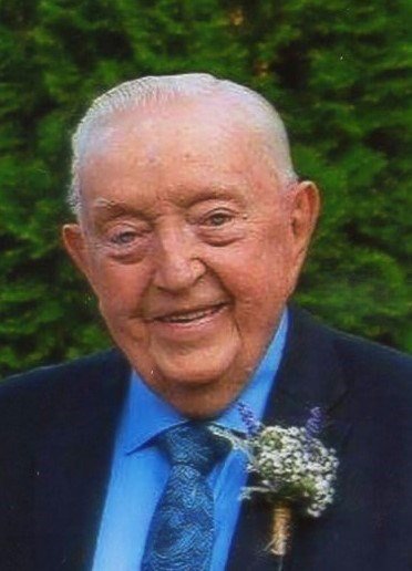 Elderly man smiling with floral boutonnière.