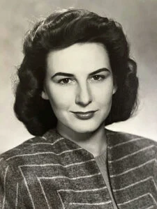 Black and white portrait of a woman smiling.