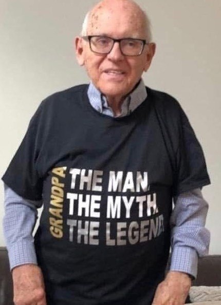 Elderly man wearing 'Grandpa: The Man, Myth, Legend' shirt.