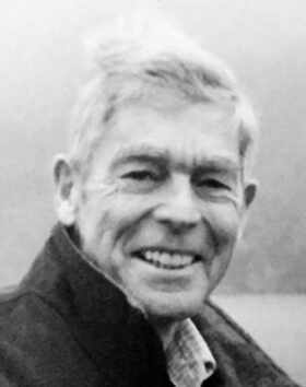 Elderly man smiling outdoors in jacket