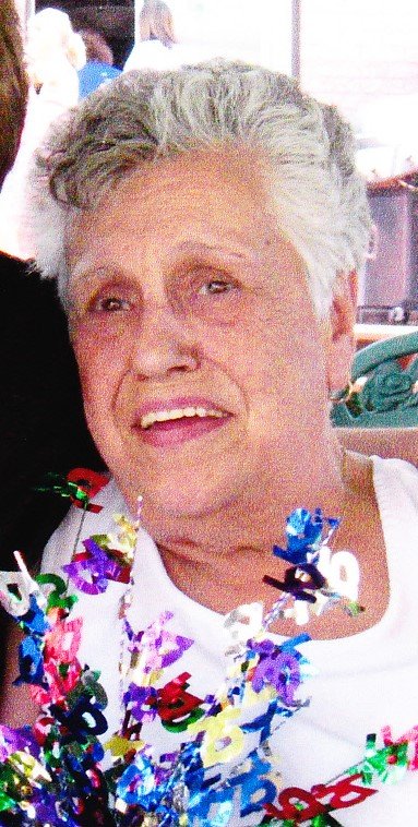 WRY, Marie "Florence" Wry Smiling elderly woman holding colorful 80-year celebration decoration.
