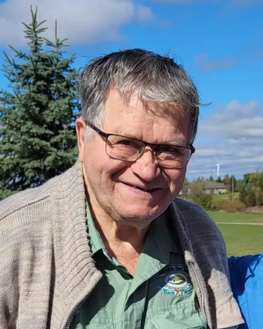Smiling older man outdoors in sunny weather.