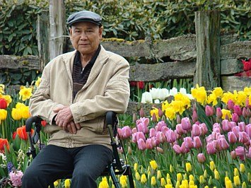 Man sitting in garden with colorful tulips