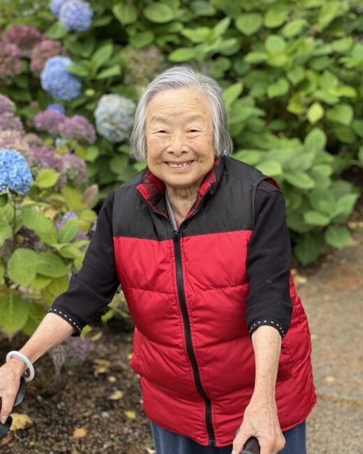Smiling person in garden with hydrangeas