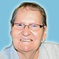 Smiling elderly person with glasses on blue background.