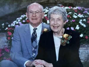 Elderly couple smiling at garden event.
