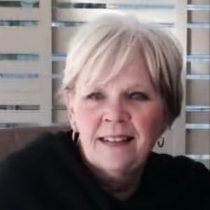 Smiling woman with short hair indoors.