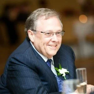 Smiling man in suit at event.