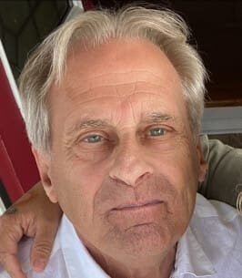Older man with gray hair and serious expression.