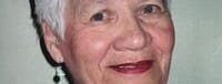 Smiling elderly woman with short white hair.