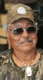 Smiling man in sunglasses and camo hat