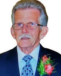 Elderly man in suit with flower boutonniere.