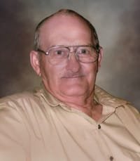 Elderly man wearing glasses and beige shirt