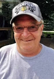 Older man smiling in Champions cap outdoors.