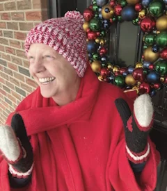 Smiling person in red with Christmas decorations