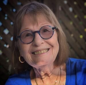 Smiling woman wearing glasses and blue shirt
