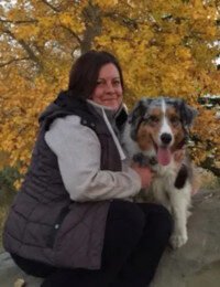 Woman with dog in autumn scenery.