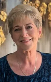 Smiling woman with short blonde hair and earrings