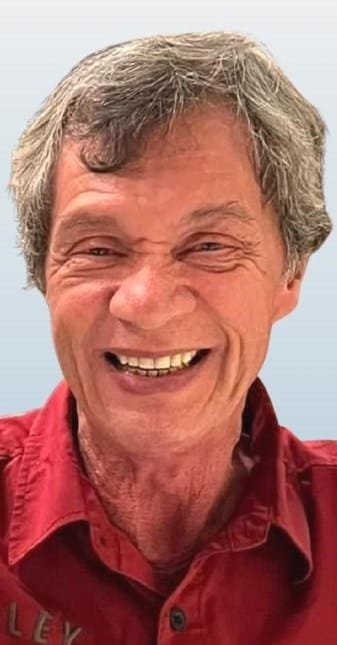 Smiling man in red shirt.