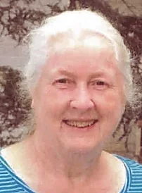 Smiling elderly woman with white hair in striped shirt.