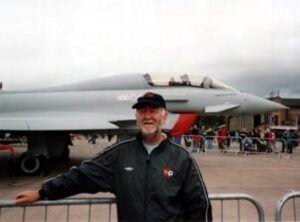 Man standing in front of military aircraft display.