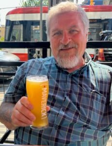 Man enjoying a beer on a sunny patio.