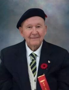 Elderly man in uniform with poppy and ribbon