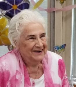 Elderly woman smiling with colorful background.