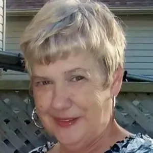 Smiling woman outside near wooden fence