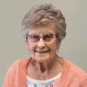 Smiling elderly woman in peach cardigan