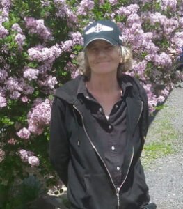 Person standing in front of blooming purple flowers