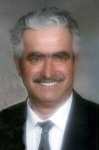 Smiling man with gray hair and mustache