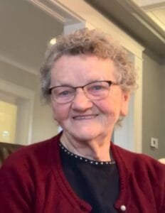 Smiling elderly woman with glasses and curly hair