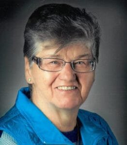 Smiling person wearing glasses and blue jacket