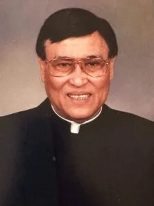 Man in clerical attire smiling at camera