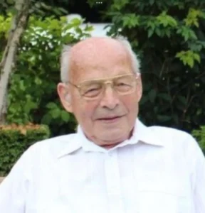 Elderly man in white shirt outdoors