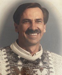 Smiling man in sweater portrait.