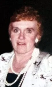 Woman with pearls and floral jacket smiling