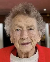 Elderly woman smiling, wearing a red sweater