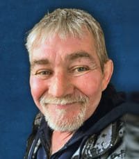 Smiling man with gray hair and beard.