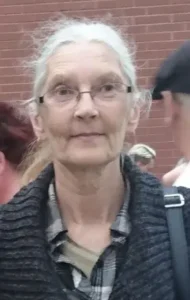 Elderly woman wearing glasses in outdoor setting