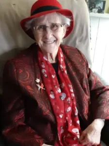 Smiling elderly woman in red hat and scarf